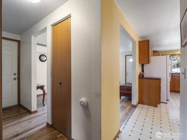 hallway with light wood-style floors and baseboards