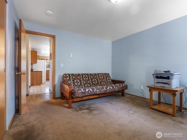 carpeted living area featuring baseboards