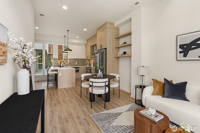living area featuring light wood-style flooring and recessed lighting