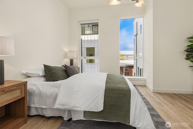 bedroom featuring wood finished floors and baseboards