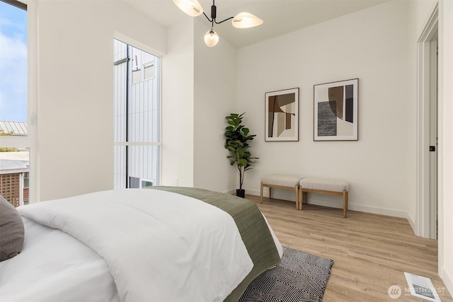 bedroom with light wood finished floors and baseboards