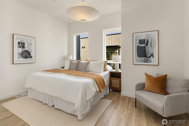 bedroom with light wood-type flooring and baseboards