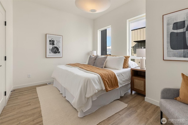 bedroom with light wood-style flooring and baseboards