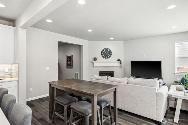 9844 Prospect Pl, Gig Harbor, WA 98332 - living area with dark wood-style flooring, a glass covered fireplace, recessed lighting, and baseboards