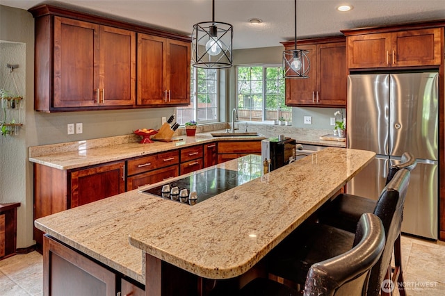 231 Valley Way, Woodland, WA 98674 - kitchen with freestanding refrigerator, a sink, a breakfast bar area, light stone countertops, and recessed lighting