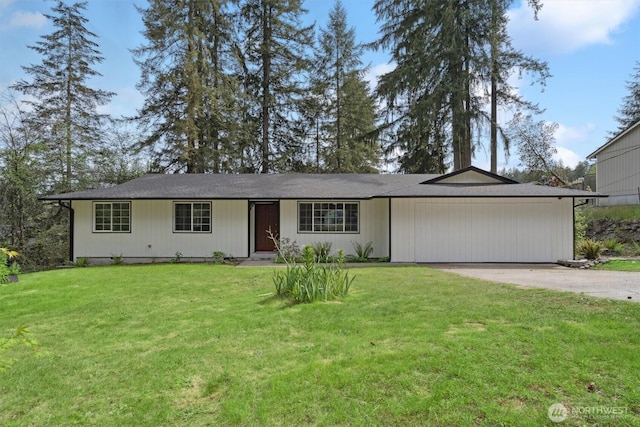 ranch-style house with concrete driveway and a front lawn