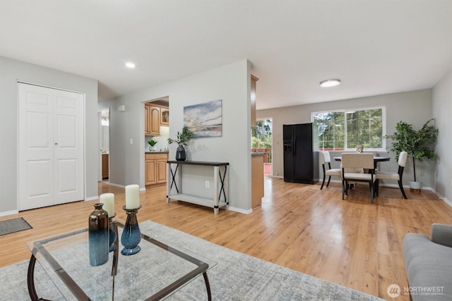 living room featuring light wood-type flooring, baseboards, and recessed lighting