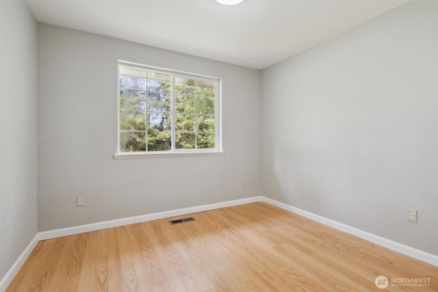 spare room featuring wood finished floors and baseboards