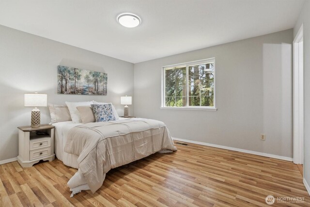 bedroom with baseboards and light wood-type flooring