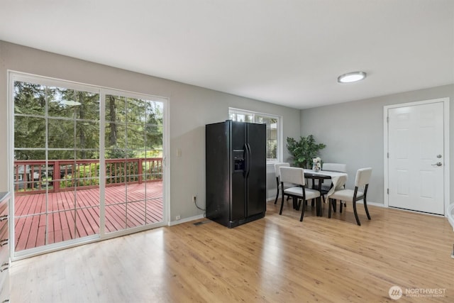 dining room featuring light wood-style flooring and baseboards