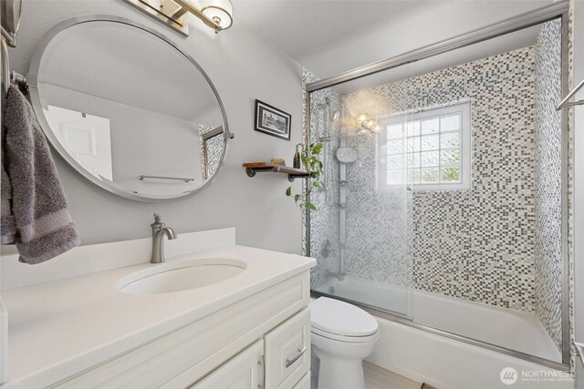 full bath with a chandelier, vanity, toilet, and enclosed tub / shower combo