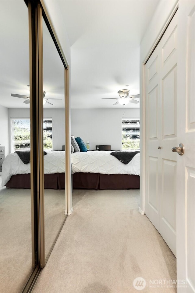bedroom with light colored carpet and a ceiling fan
