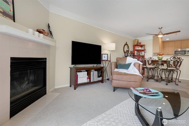 living area featuring a fireplace, light colored carpet, ornamental molding, ceiling fan, and baseboards