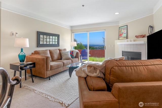 carpeted living area featuring ornamental molding and a tiled fireplace
