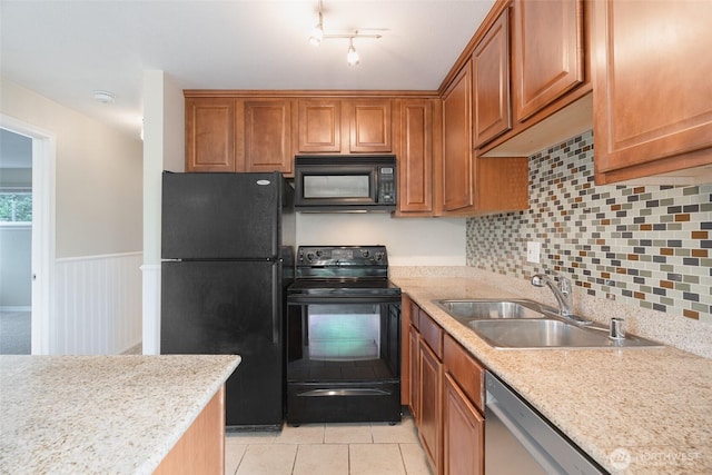 20320 Bothell-Everett Hwy Unit D301, Bothell, WA 98012 - kitchen featuring black appliances, a sink, brown cabinetry, a wainscoted wall, and decorative backsplash