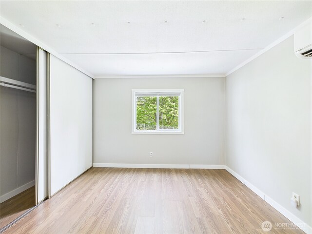 212 Old Owen Rd Unit 43, Sultan, WA 98294 - unfurnished bedroom featuring wood finished floors, an AC wall unit, crown molding, baseboards, and a closet