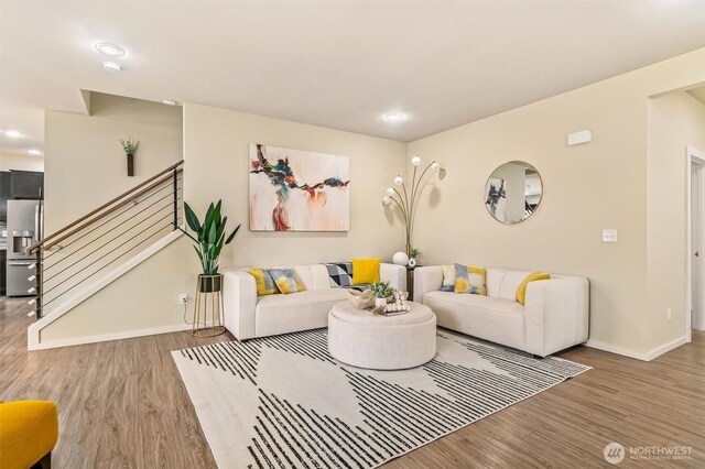 living area with wood finished floors, stairway, baseboards, and recessed lighting