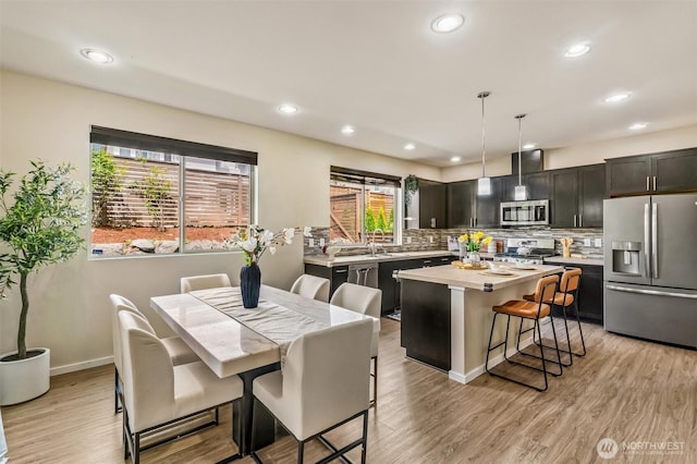 dining area with recessed lighting, light wood-style flooring, and baseboards