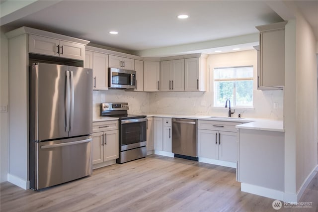 343 Hawkins Rd, Winlock, WA 98596 - kitchen with appliances with stainless steel finishes, a sink, light wood-style floors, backsplash, and light countertops