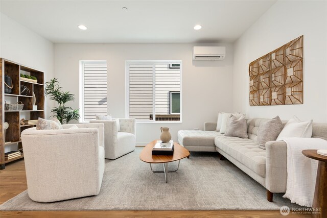 living room with a wall unit AC, wood finished floors, and recessed lighting