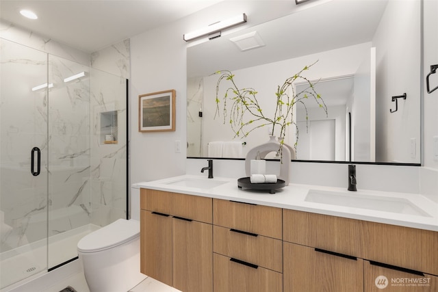 full bath with toilet, a marble finish shower, double vanity, and recessed lighting