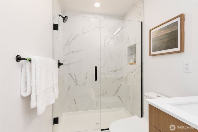bathroom with toilet, a marble finish shower, recessed lighting, and vanity