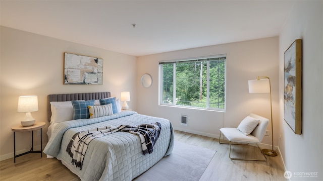 bedroom with baseboards and light wood finished floors