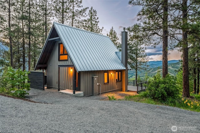 981 Nighthawk Ridge Ln, Leavenworth, WA 98826 - view of front of property featuring a chimney, a metal roof, board and batten siding, and a garage