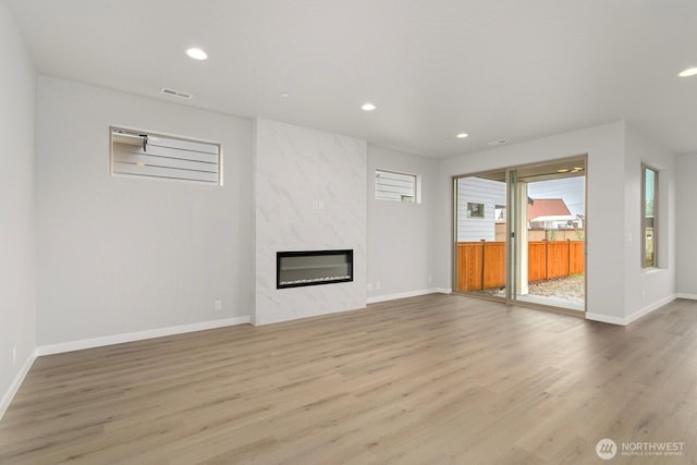 13302 SE 238th Pl Unit 7, Kent, WA 98042 - unfurnished living room featuring light wood-style flooring, a premium fireplace, recessed lighting, and baseboards