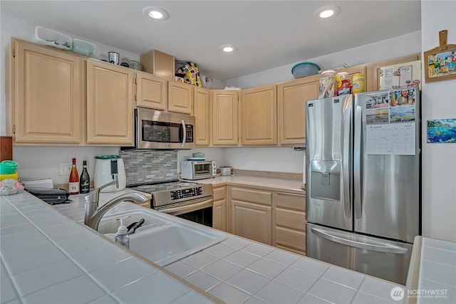 5400 Harbour Pointe Blvd Unit F202, Mukilteo, WA 98275 - kitchen with stainless steel appliances, tile counters, light brown cabinets, recessed lighting, and a sink