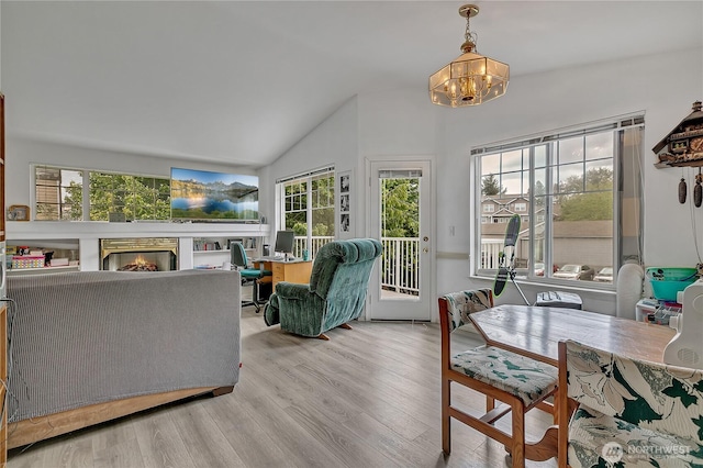 5400 Harbour Pointe Blvd Unit F202, Mukilteo, WA 98275 - living area featuring vaulted ceiling, a chandelier, wood finished floors, and a lit fireplace