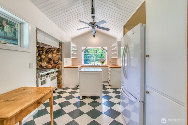 1472 White Beach Rd, Orcas Island, WA 98280 - kitchen with double oven range, freestanding refrigerator, light floors, open shelves, and white cabinetry