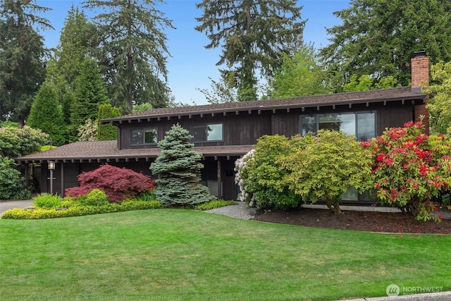 view of front facade with a front lawn and a chimney