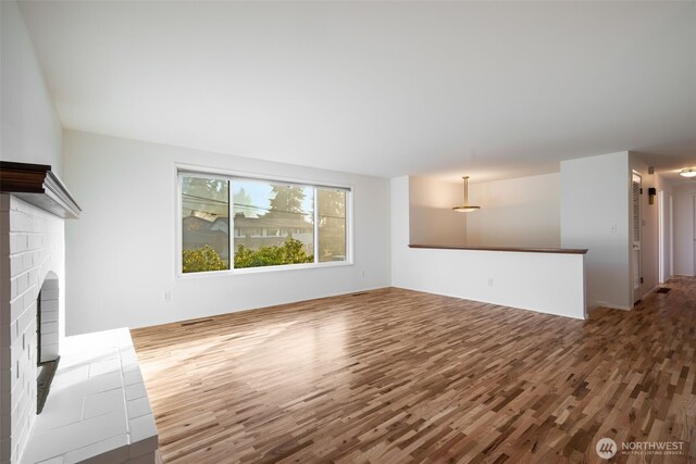 unfurnished living room with wood finished floors and a fireplace