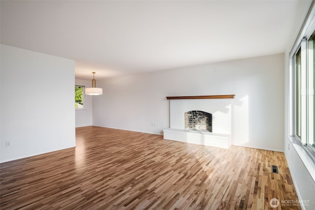 unfurnished living room with wood finished floors and a fireplace
