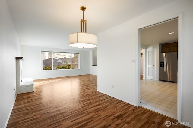 unfurnished dining area featuring wood finished floors, baseboards, and recessed lighting