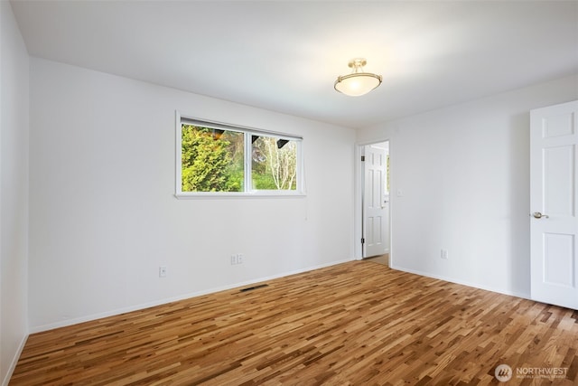 unfurnished room with wood finished floors and baseboards