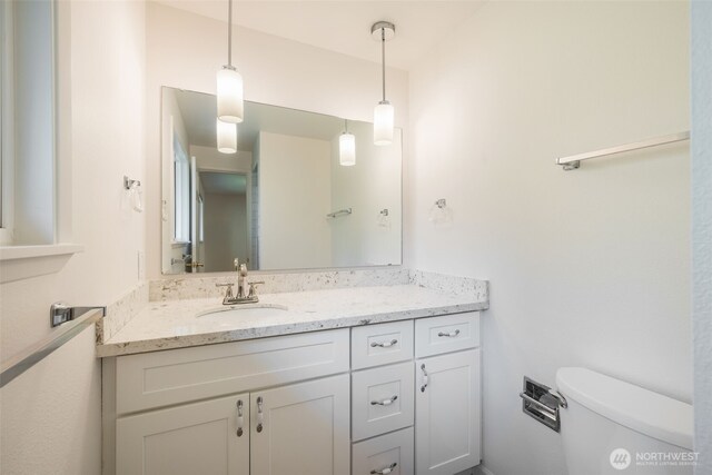 half bath featuring toilet and vanity