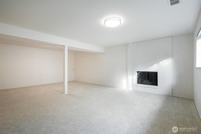 finished below grade area featuring carpet and a brick fireplace