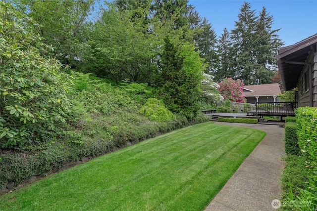 view of grassy yard with a wooden deck