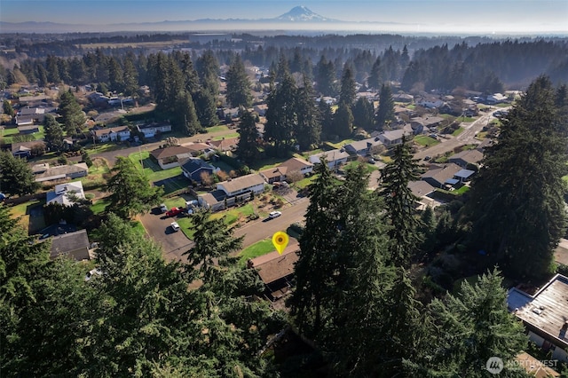 aerial view of property's location featuring a heavily wooded area and nearby suburban area