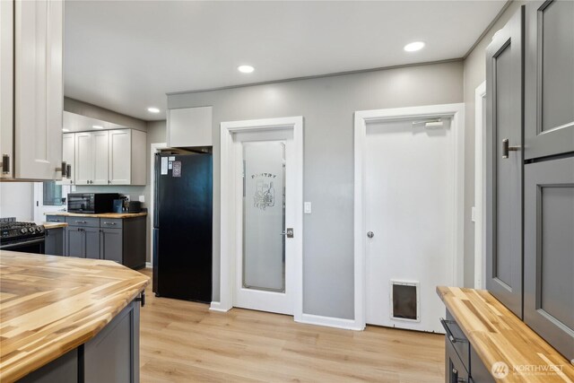 301 S 6th St, Mount Vernon, WA 98274 - kitchen with butcher block countertops, black appliances, light wood finished floors, recessed lighting, and gray cabinetry