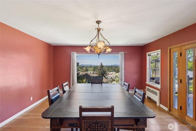 301 S 6th St, Mount Vernon, WA 98274 - dining area featuring radiator heating unit, light wood finished floors, a chandelier, and baseboards
