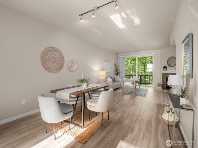 3116 164th St SW Unit 1804, Lynnwood, WA 98087 - dining space with rail lighting, wood finished floors, a tile fireplace, and baseboards