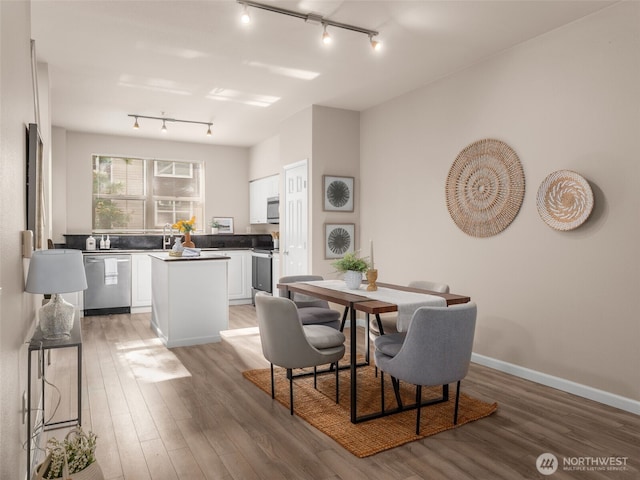 3116 164th St SW Unit 1804, Lynnwood, WA 98087 - dining area featuring rail lighting, light wood-style floors, and baseboards