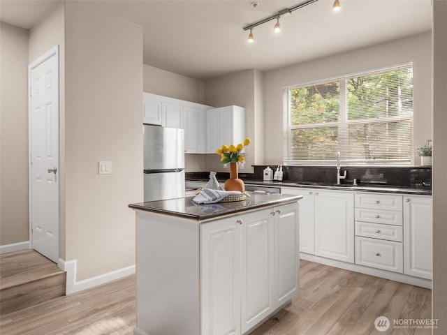 3116 164th St SW Unit 1804, Lynnwood, WA 98087 - kitchen with freestanding refrigerator, dark countertops, light wood-style flooring, and a sink