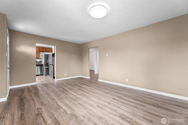 807 S Howard St, Tacoma, WA 98465 - unfurnished living room featuring light wood-type flooring and baseboards