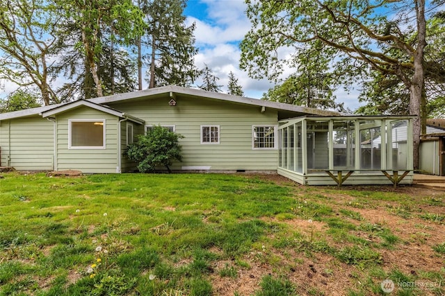 rear view of property with a sunroom, crawl space, and a lawn