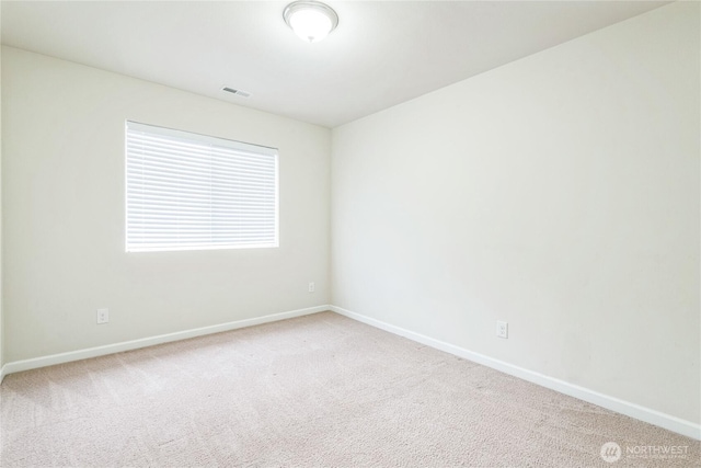 carpeted empty room featuring baseboards