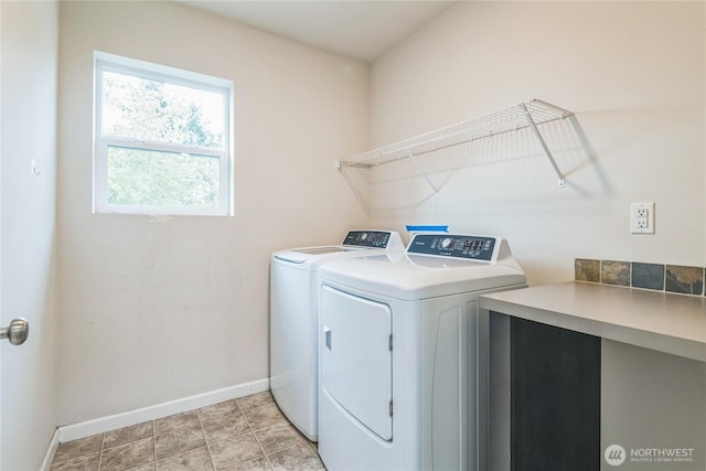 washroom with washing machine and dryer and baseboards